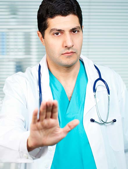 мужчина врач делает рукой жест предупреждения